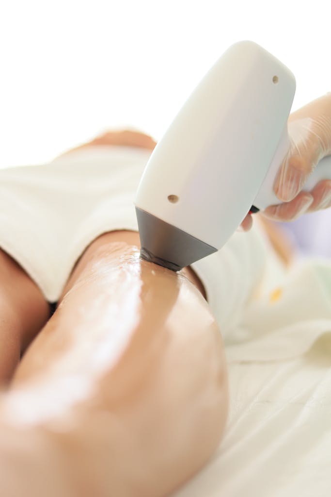Close-up of laser hair removal on woman's leg in professional spa setting.